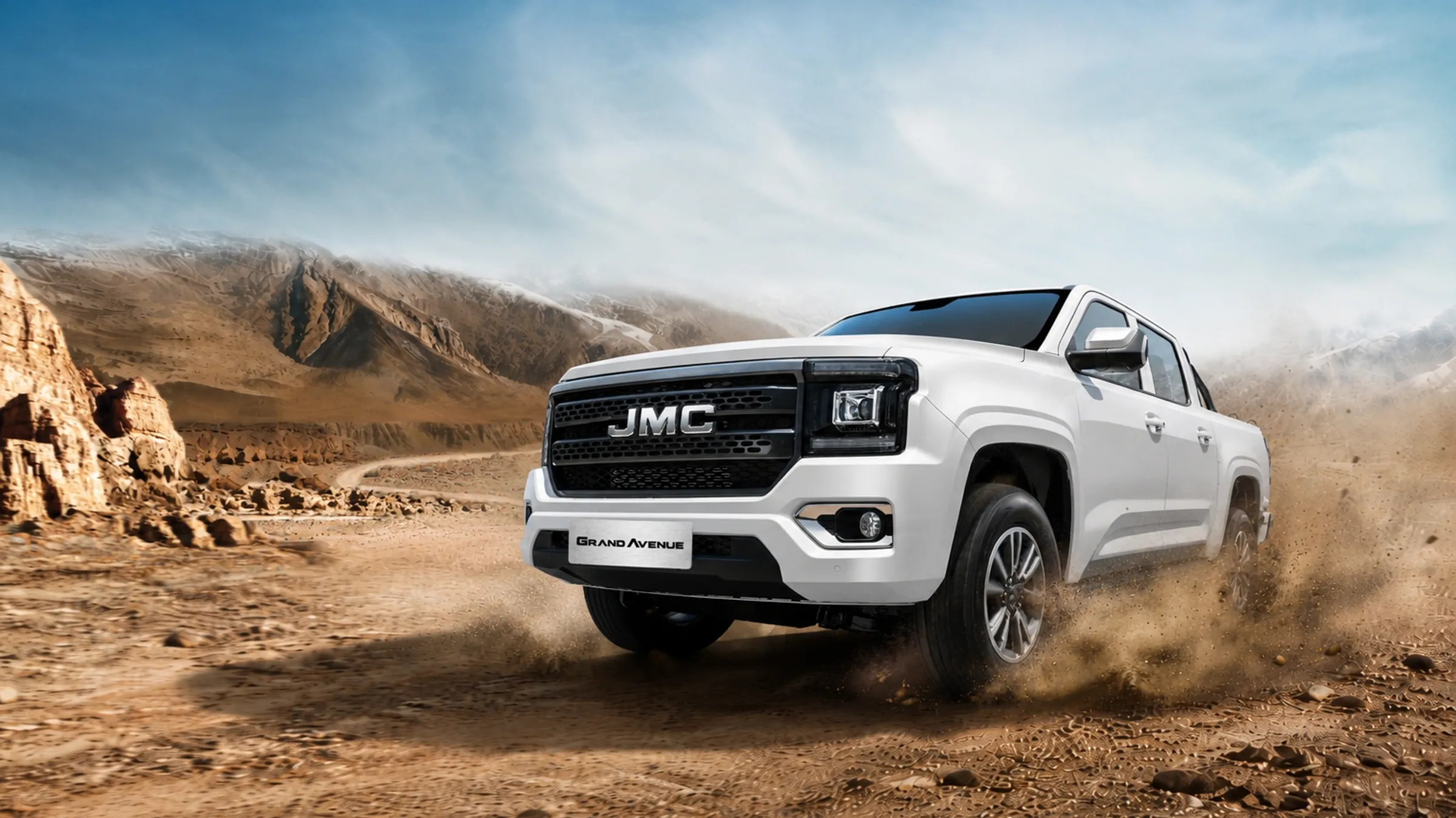 Pick-up JMC Grand Avenue double cabine blanc roulant dans un paysage désertique