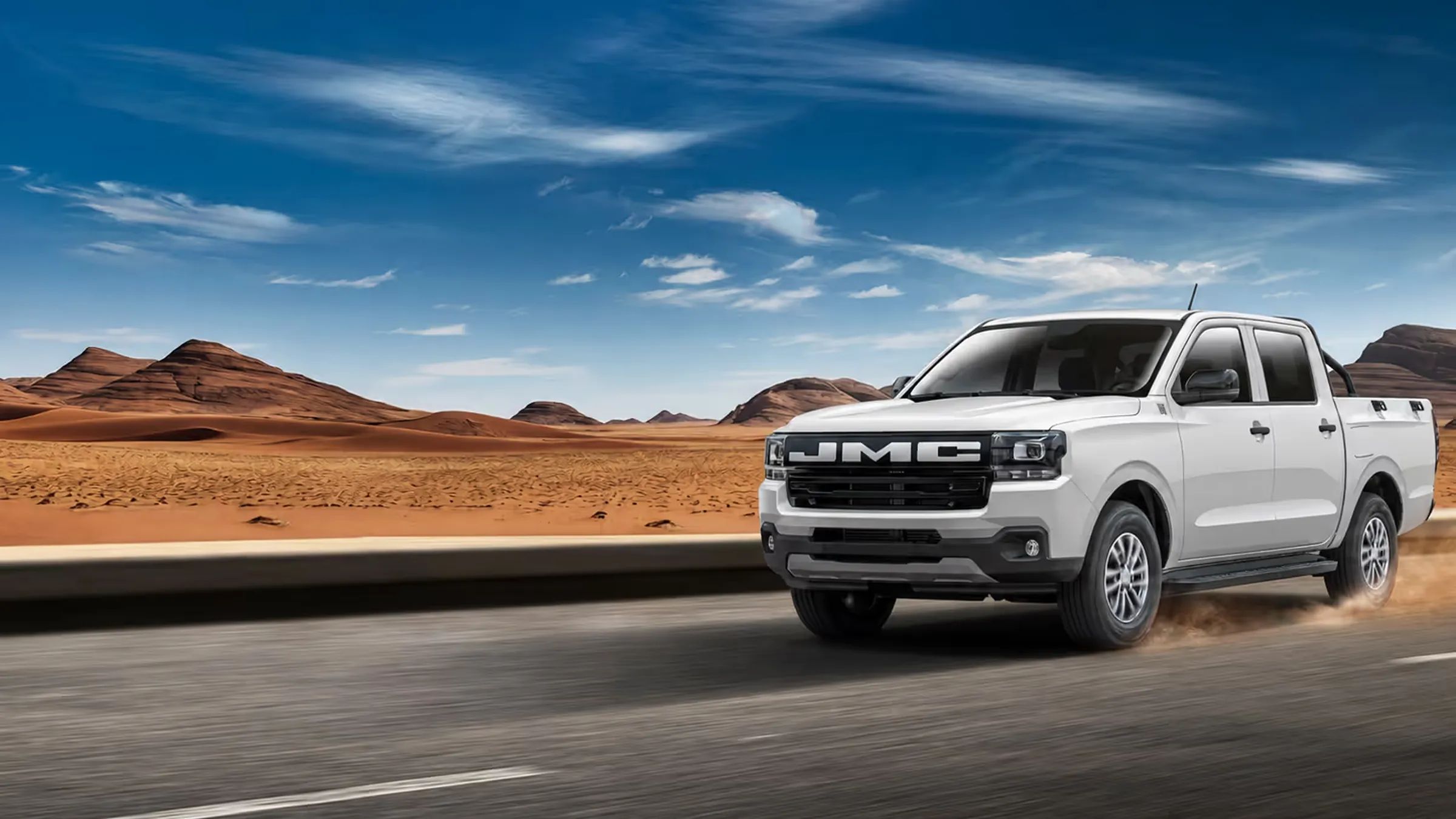 Pick-up JMC Vigus double cabine blanc roulant sur une route désertique